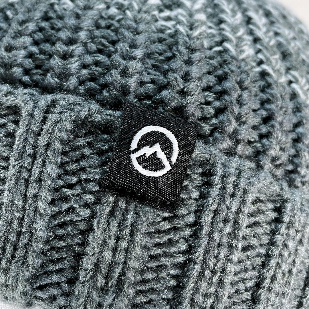 Close up of Domex logo on Grey ombre gradient cuffed beanie in a chunky knit