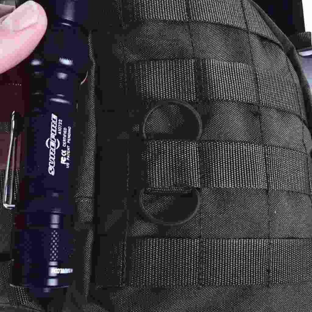 Close up of cable manager  in Molle system with torch next to it  - Black 