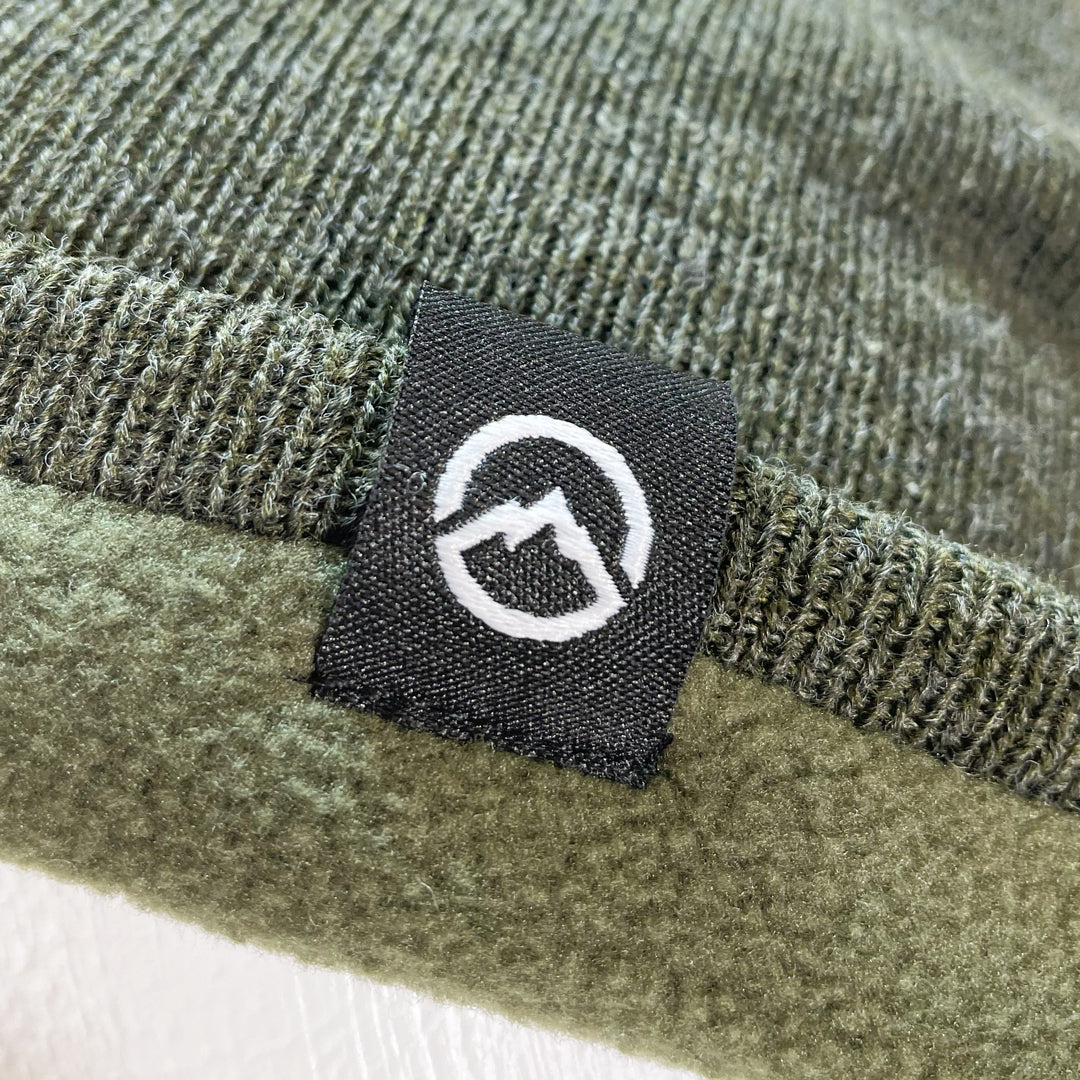 Close up of Domex logo on Forest green fine-knit beanie 