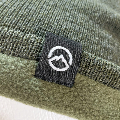 Close up of Domex logo on Forest green fine-knit beanie 