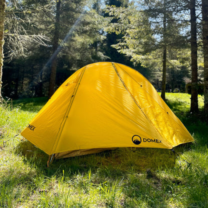 Yellow Domex Ascent 1 tent pitched in forest