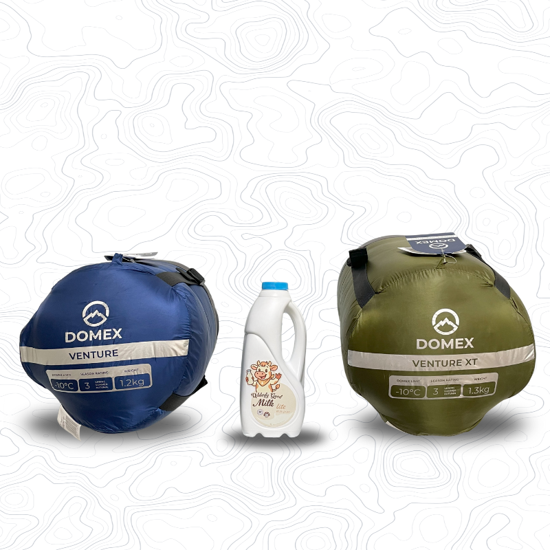 Image of bottoms of compression sacks for Domex Venture Sleeping Bag (blue, 10C, 1.2kg) and Venture XT Sleeping Bag (green, -10C, 1.3kg) with a 1 litre bottle of milk between them for scale | GENERAL