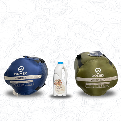 Image of bottoms of compression sacks for Domex Venture Sleeping Bag (blue, 10C, 1.2kg) and Venture XT Sleeping Bag (green, -10C, 1.3kg) with a 1 litre bottle of milk between them for scale | GENERAL