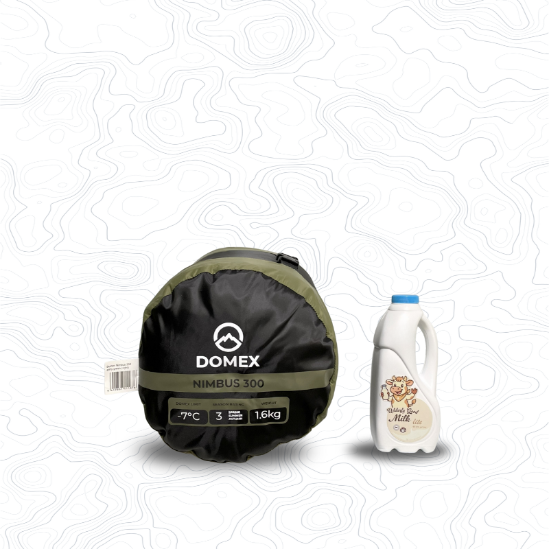Scale image of Domex Nimbus 300 Sleeping Bag - -7C, 1.6 kg | On its side in stuff sack next to 1 L bottle of milk