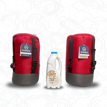 Domex Versalite Sleeping Bags in compession sacks and in red on either side of 1 litre bottle of milk for scale. Left is the standard sized bag, right is the XT | GENERAL